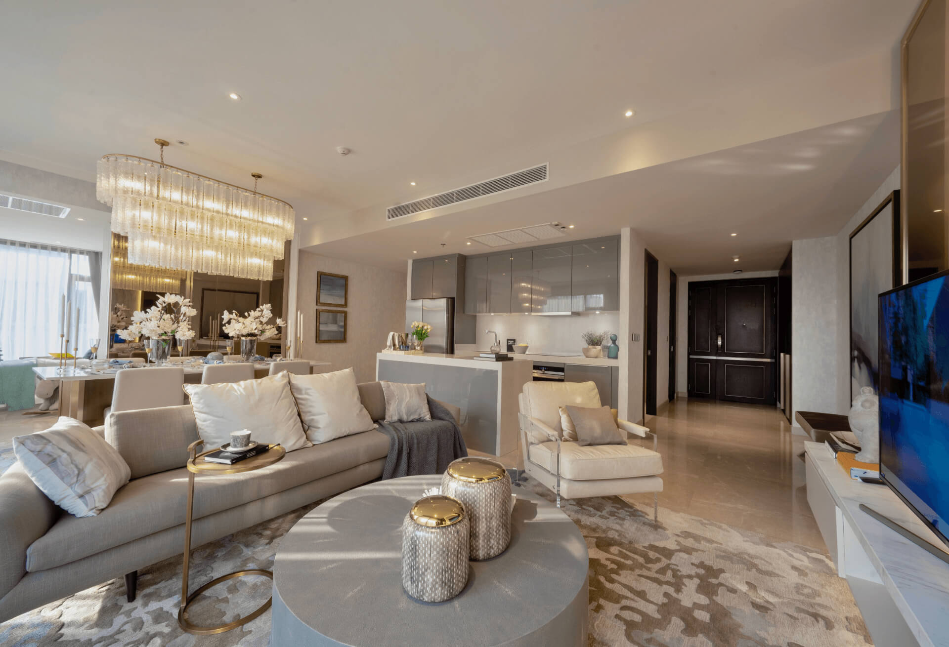 Nivati Thonglor 23 show residence living and dining room with chandelier and grey sofa